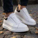 Chaussures rehaussantes blanches portées en extérieur Chaussures rehaussantes blanches portées en extérieur